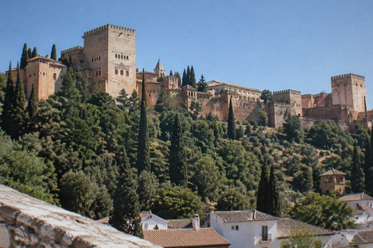 The Alhambra palace complex on its hill above the city of Granada under a clear sky