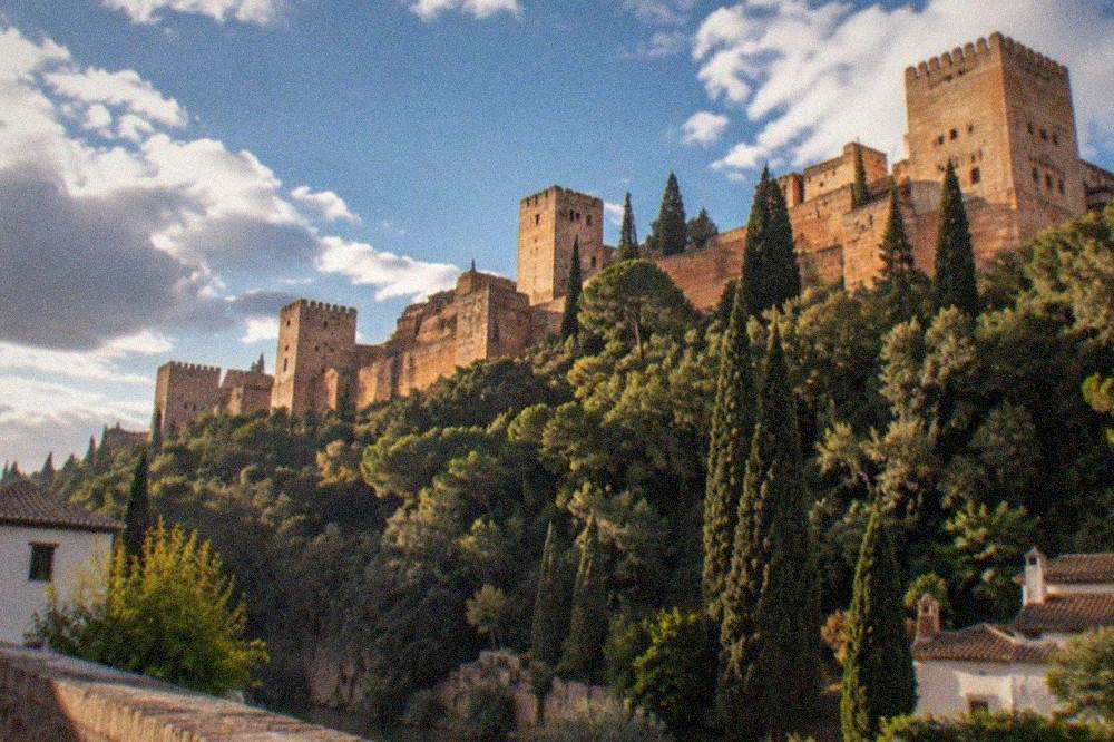 The Alhambra palace walls seen at dusk from a viewpoint across the Darro valley in Granada