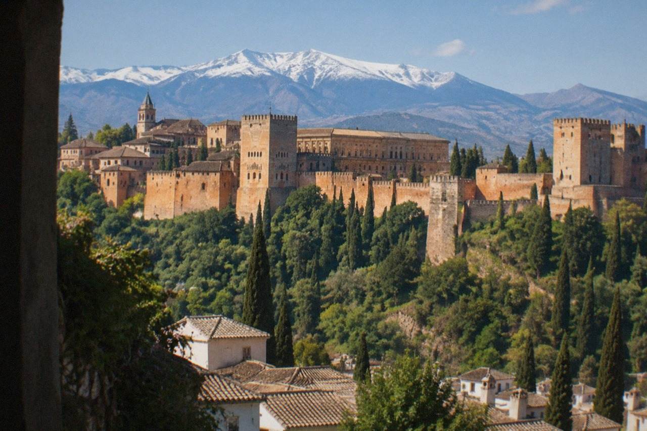 The Alhambra palace complex on its hill above the city of Granada, with the Sierra Nevada mountains in the background