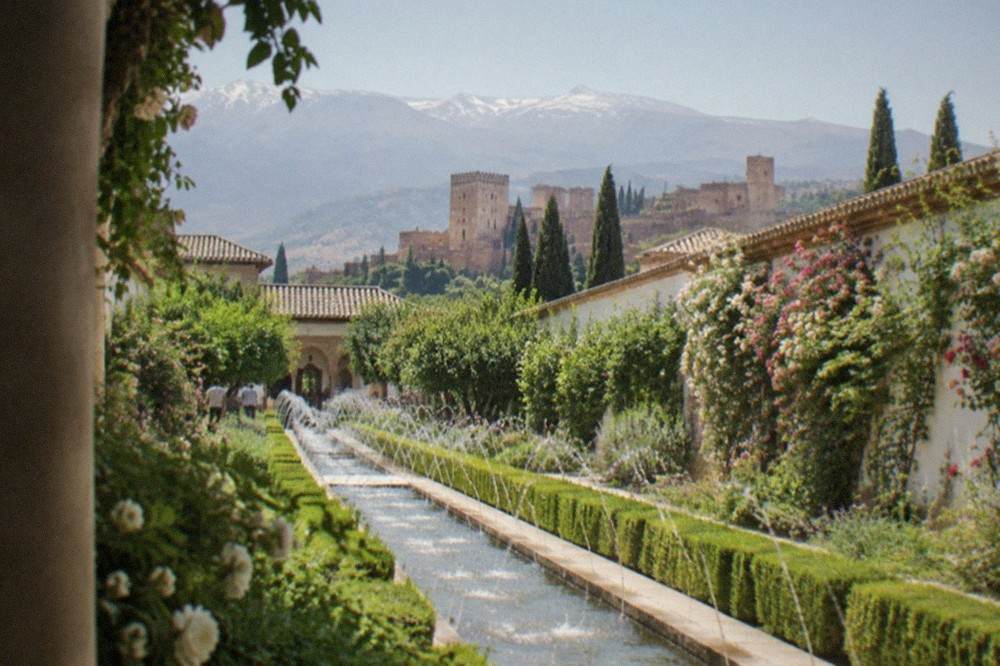 The gardens and long water channel of the Generalife with the Sierra Nevada in the background