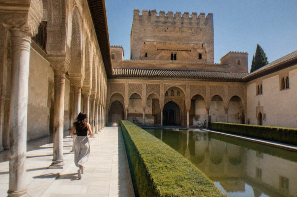 Courtyard of the Nasrid Palaces with ornate arches and a reflecting pool