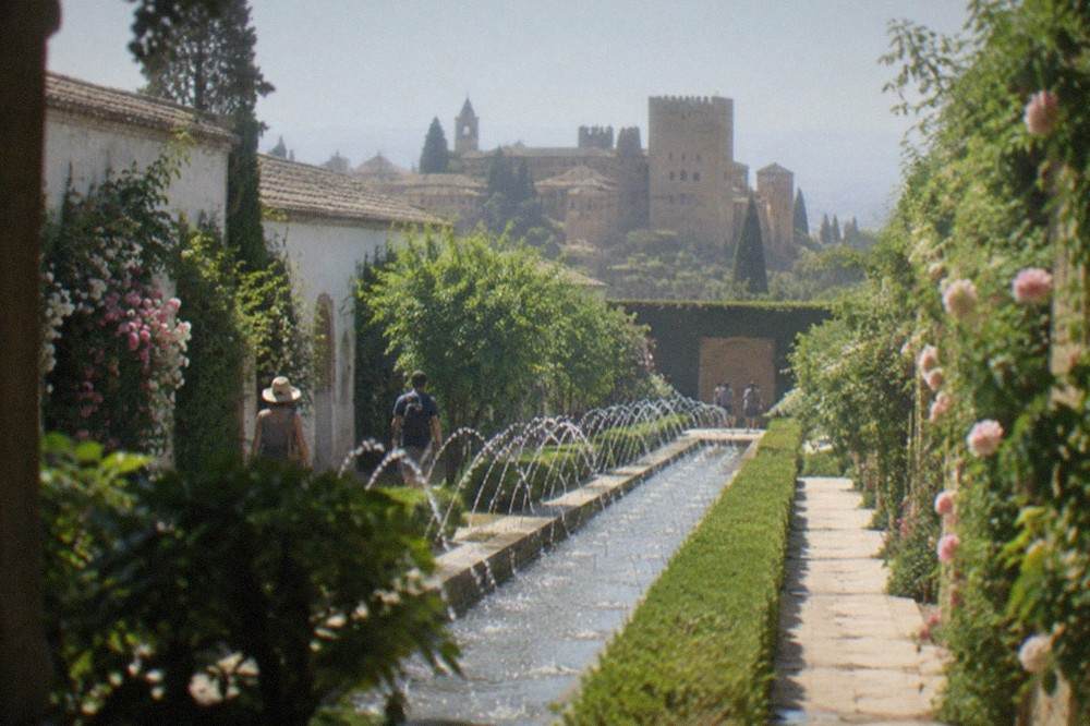 Visitors walking through the water gardens of the Generalife above Granada