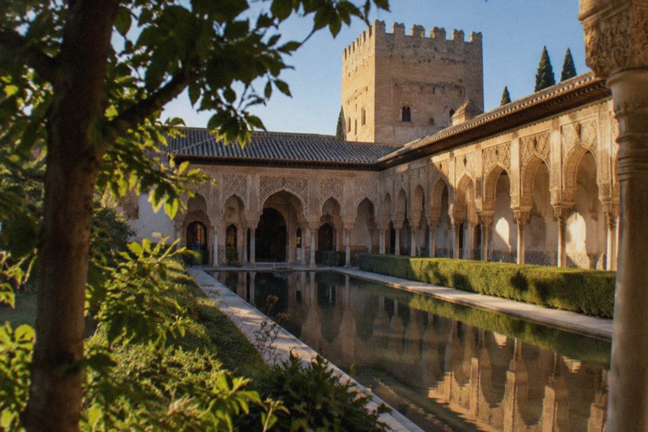 The Nasrid Palaces of the Alhambra seen from a leafy garden terrace in Granada