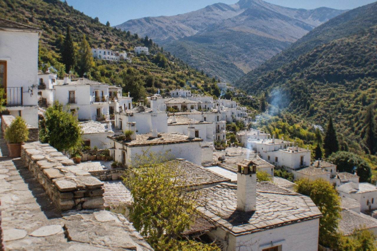 White mountain villages terraced into a green hillside valley in southern Spain