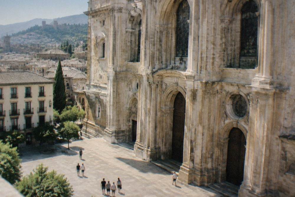 The tall white columns and stained glass windows inside Granada Cathedral's Renaissance nave