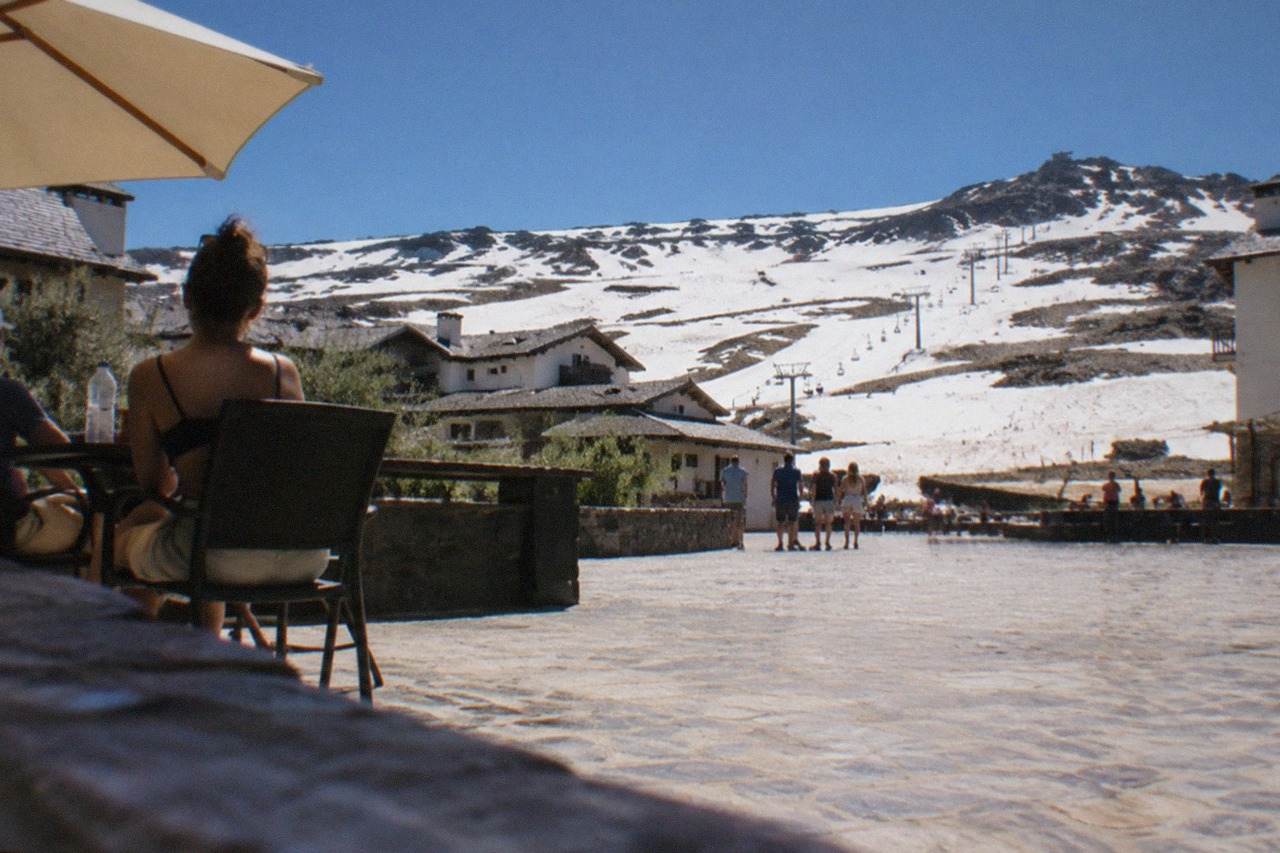 Sunlit plaza in Granada with the Sierra Nevada mountains hazy in the summer distance