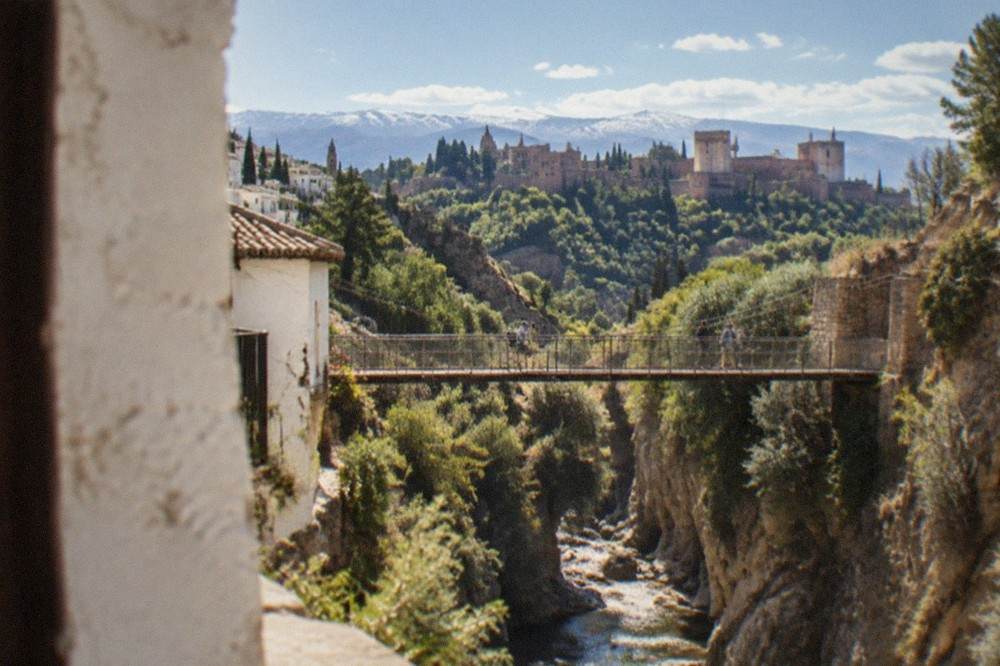 A narrow gorge with a hanging footbridge over a mountain stream near Granada