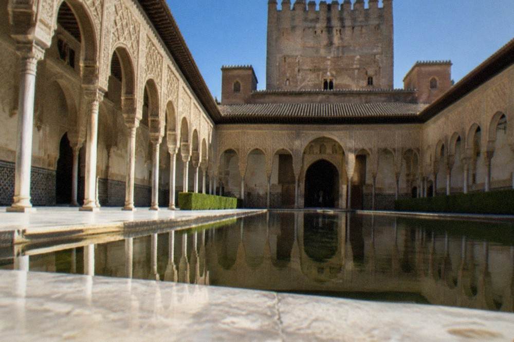 Carved stucco walls and tiled decoration inside a courtyard of the Nasrid Palaces in the Alhambra