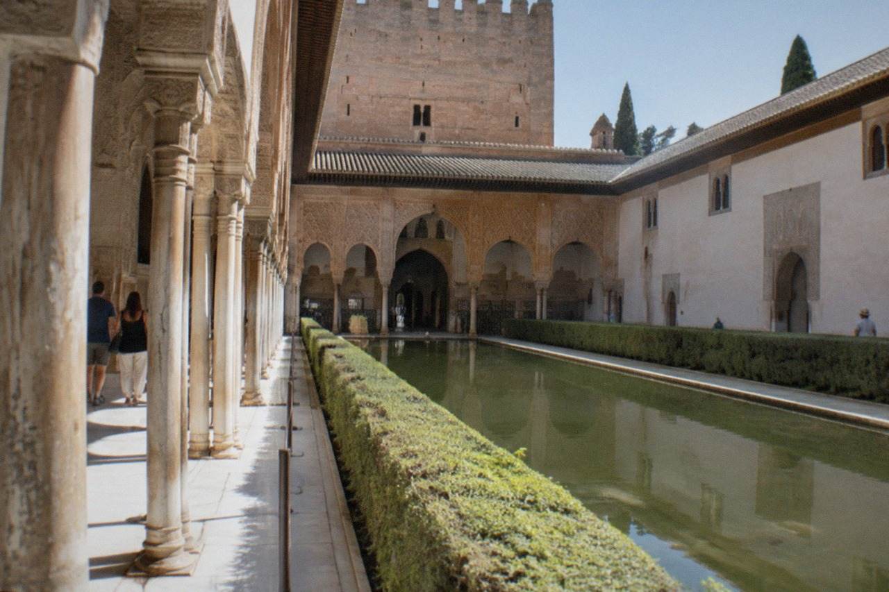 Carved stucco walls and horseshoe arches inside the Nasrid Palaces of the Alhambra