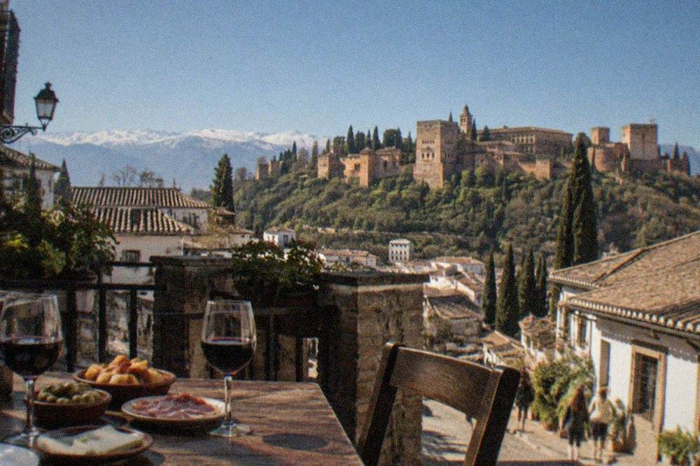 A Granada tapas bar table with small plates and glasses of wine in the evening