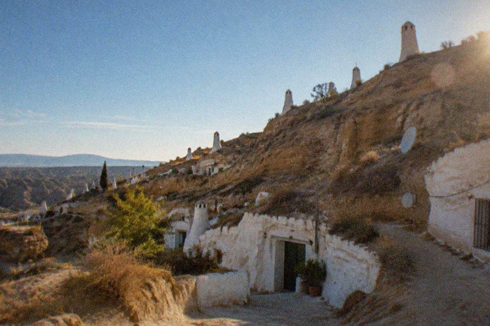 The whitewashed cave houses of Sacromonte on the hillside above Granada at dusk