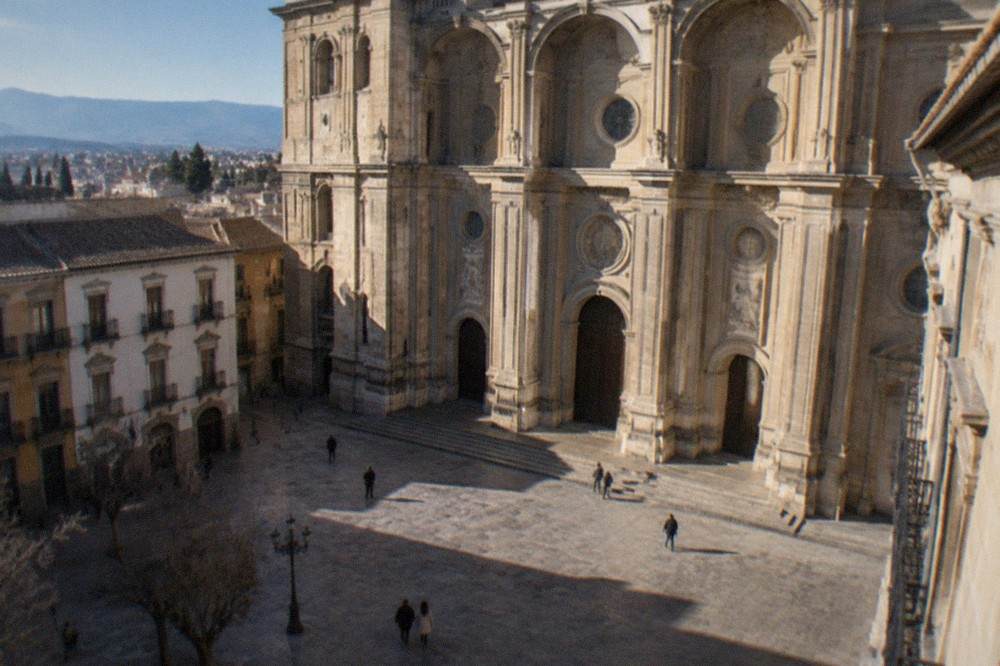 Plaza with the facade of Granada Cathedral rising above old buildings