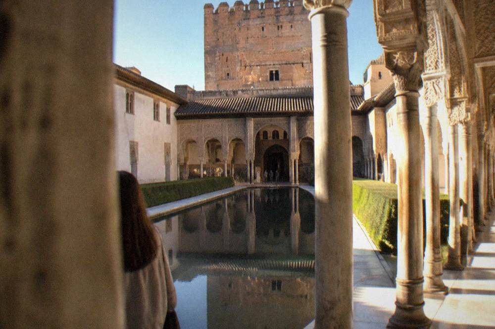Ornate arched courtyard with carved stucco walls inside the Nasrid Palaces