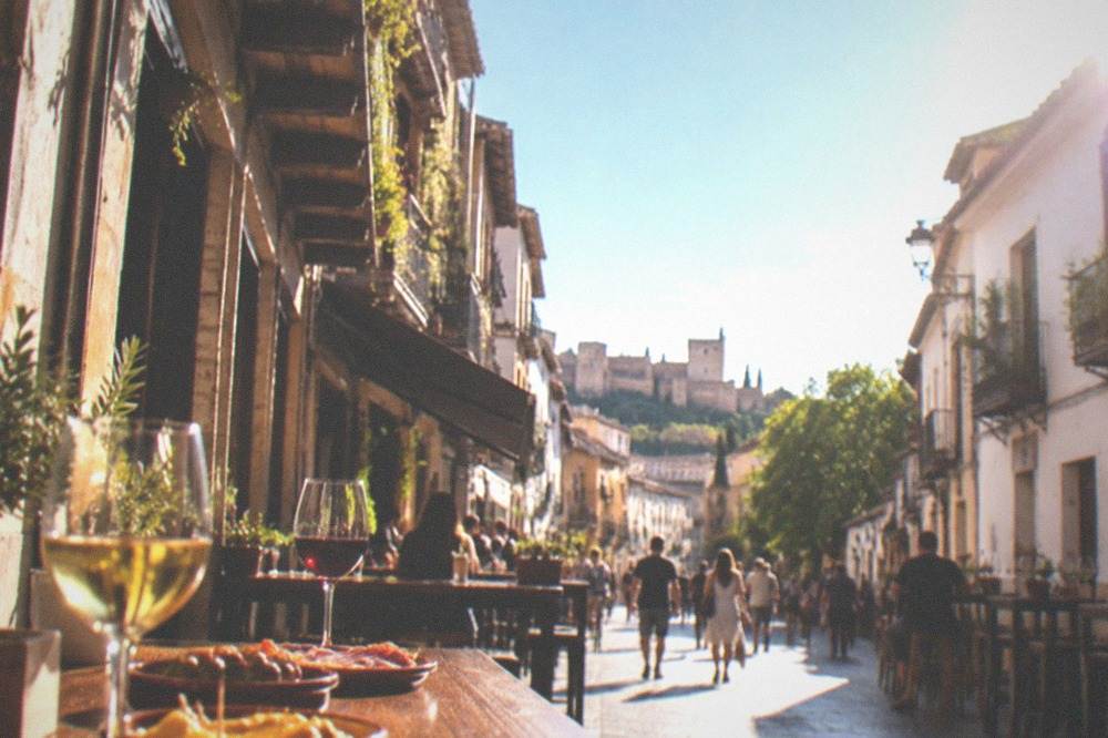 Small plates of tapas and glasses of wine on a wooden bar top