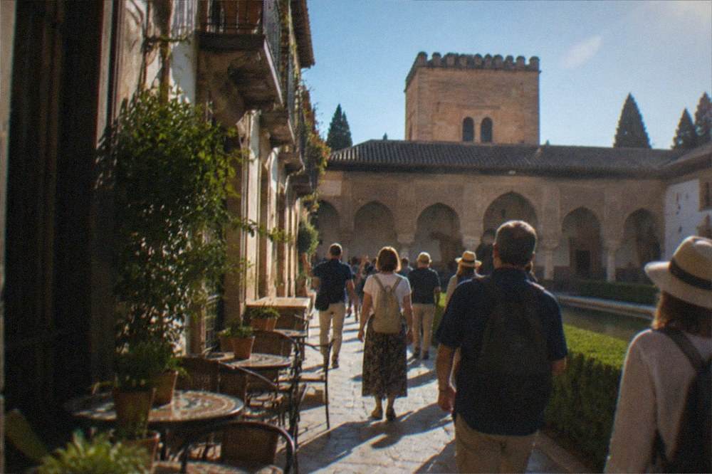 Group of visitors walking with a guide through a palace courtyard