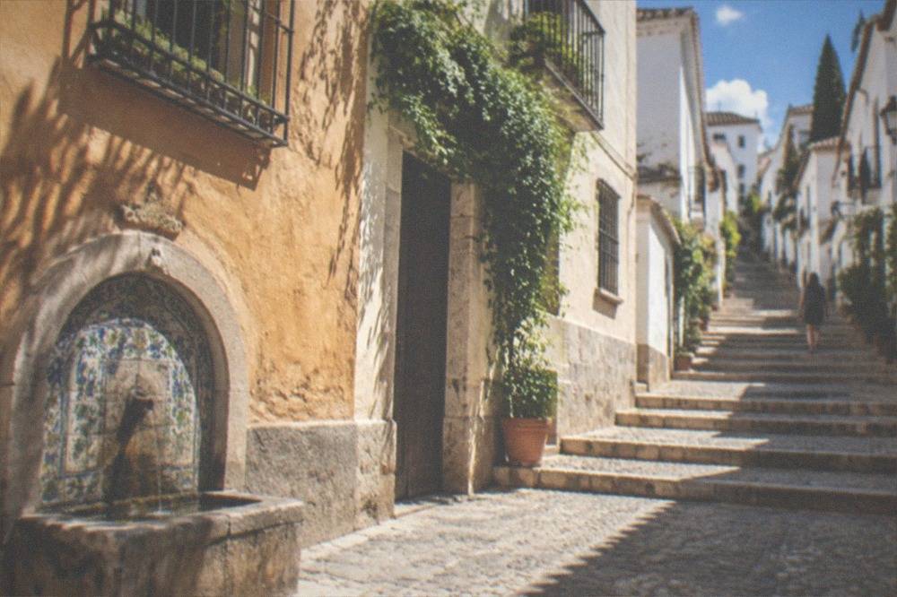 Stone steps of the Cuesta del Realejo climbing between white houses in Granada