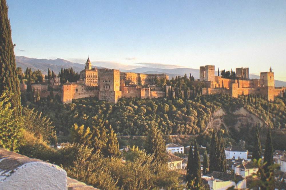 Sunset light on the Alhambra seen across a valley from a hillside viewpoint
