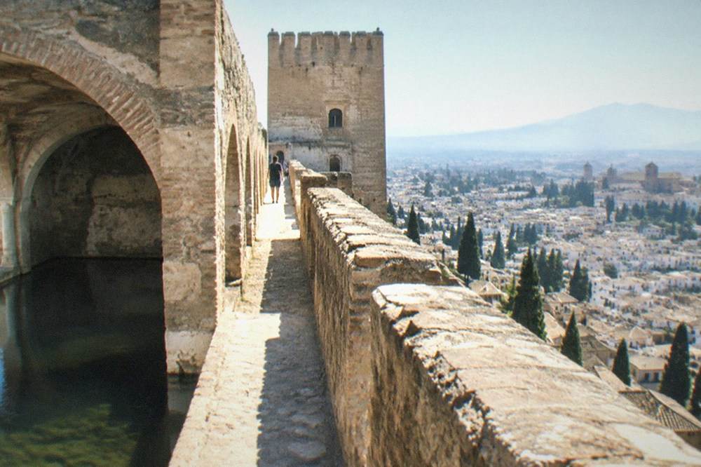 An old stone cistern inside the fortress walls, with arched ceilings above still water