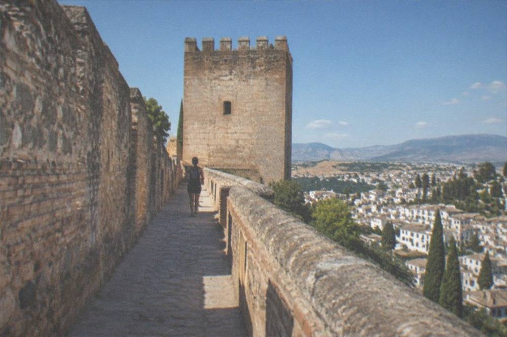 The square stone watchtower of the Alcazaba seen from inside the fortress courtyard