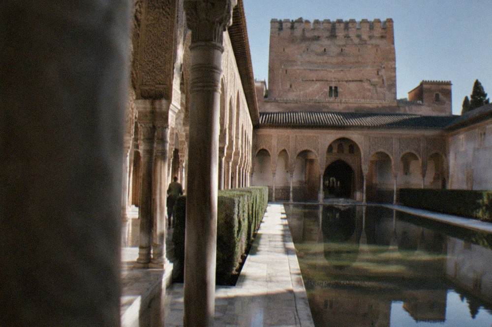 Ornate carved stucco walls and arches inside one of the Nasrid Palaces courtyards