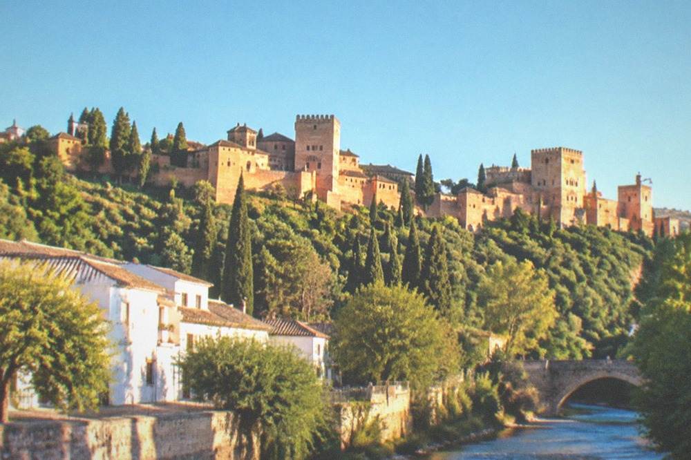 Golden late afternoon light on the Alhambra towers seen across the Darro river valley