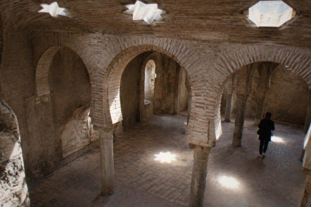 Horseshoe arch of pale brick inside the El Banuelo bathhouse in Granada