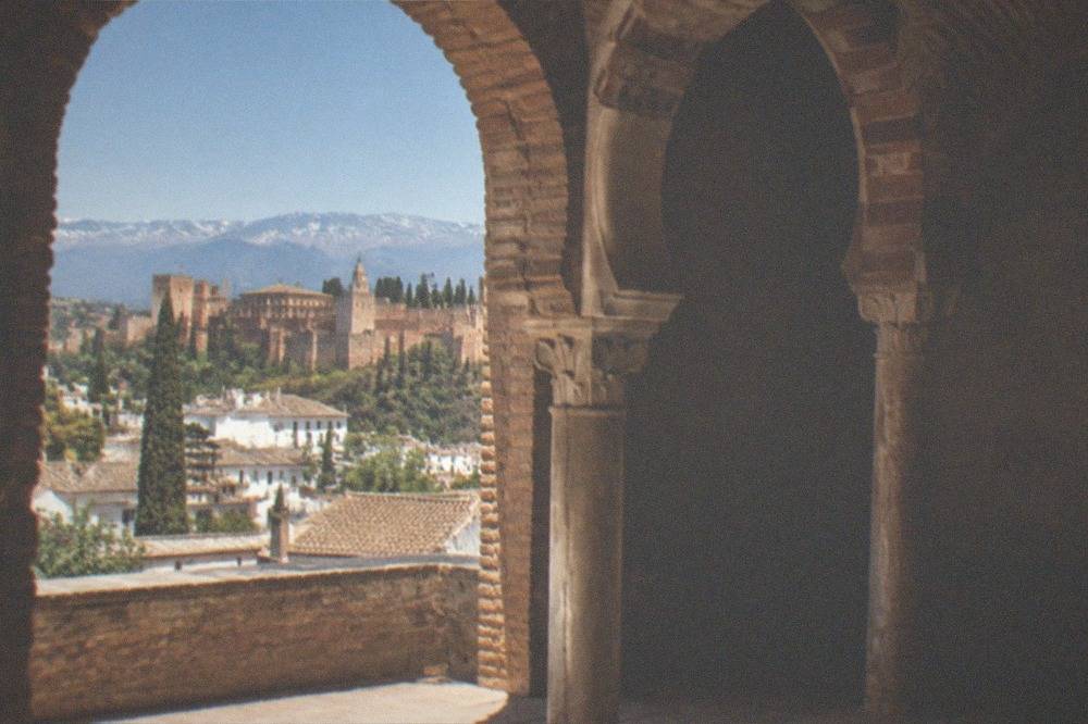 Low brick vaults and a column with a horseshoe arch in a dim Granada bathhouse room