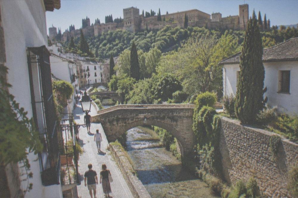 The Carrera del Darro street in Granada with the Darro river and the Alhambra above