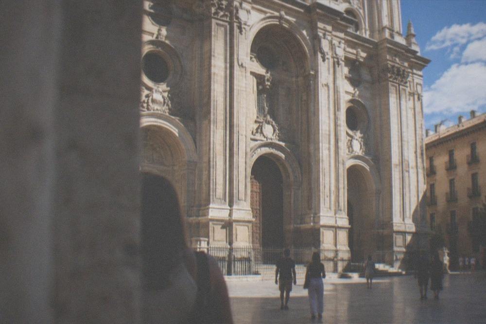 Visitors walking through the cathedral interior past stone columns