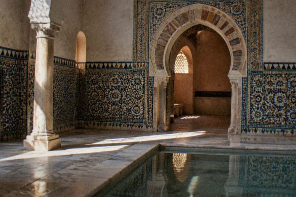 Detail of colored ceramic tiles and a horseshoe arch inside a Granada bathhouse
