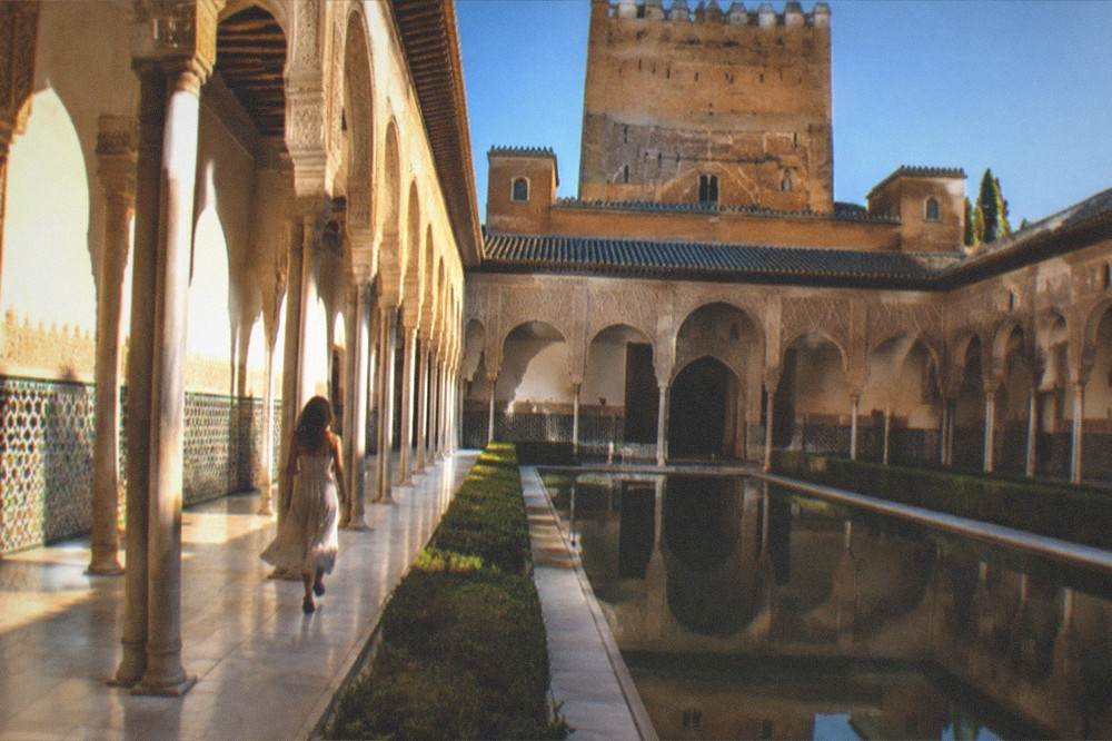 Intricate geometric tilework covering the lower walls of a palace hall