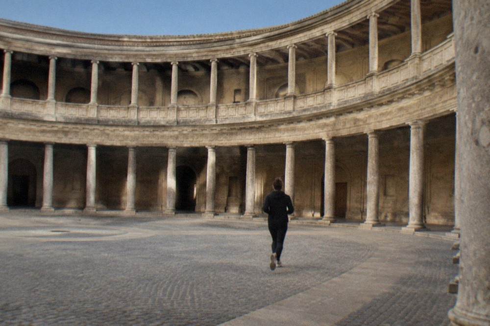 The rusticated stone facade of the Palace of Charles V with its arched entrance