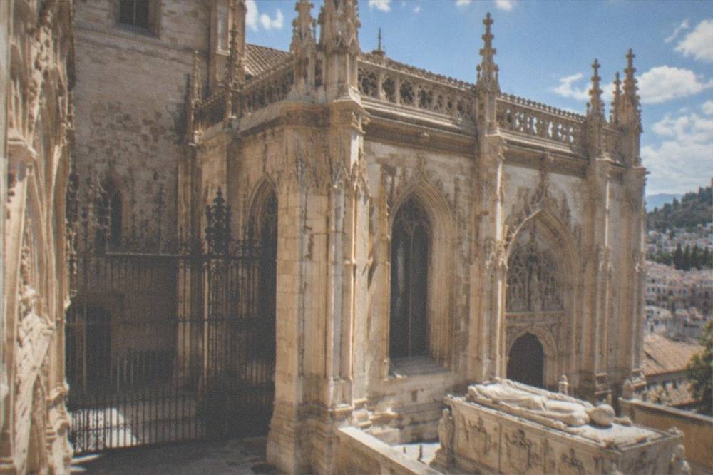 Marble tomb of a Catholic Monarch carved with heraldic detail in the chapel nave