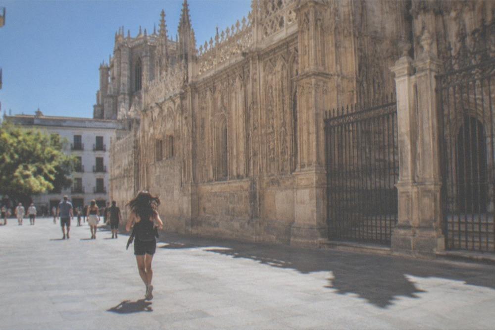 Plaza between the Royal Chapel and Granada Cathedral with visitors walking