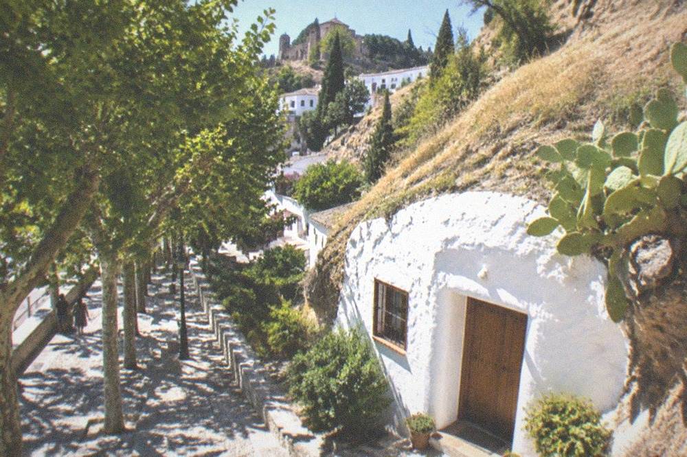 The Paseo de los Tristes promenade with plane trees and the hillside rising behind it