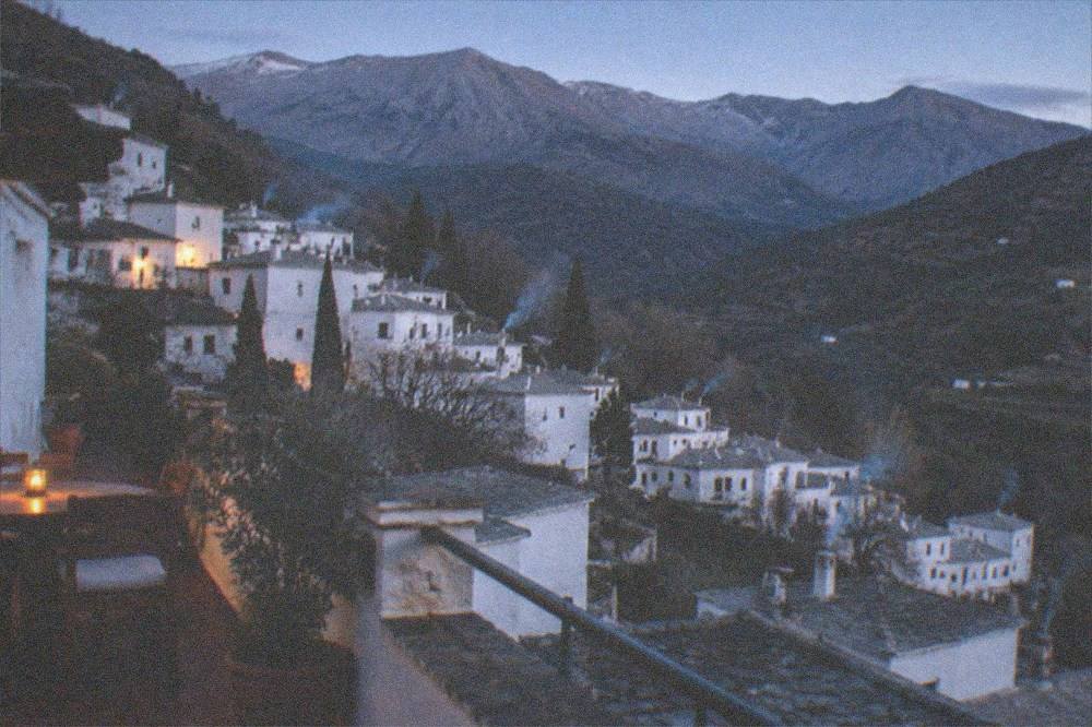 A village guesthouse terrace overlooking terraced hillsides at dusk