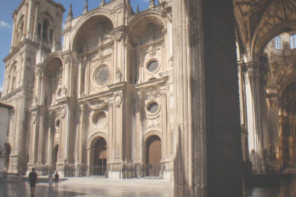 The ornate interior of Granada Cathedral with its tall columns and gilded altarpiece
