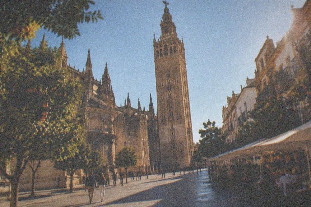A lit-up Seville street with tapas bars and outdoor tables in the evening