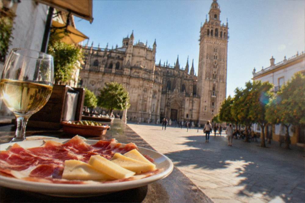 A plate of jamon and local cheese on a tapas bar counter in Seville