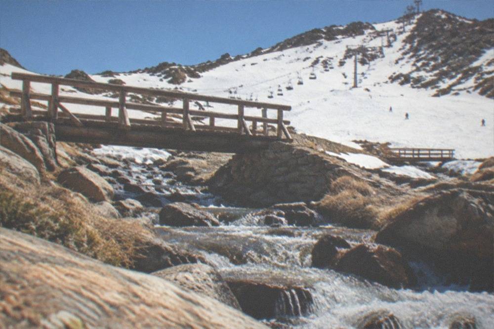 Mountain stream running through a narrow rocky gorge with wooden footbridge crossings
