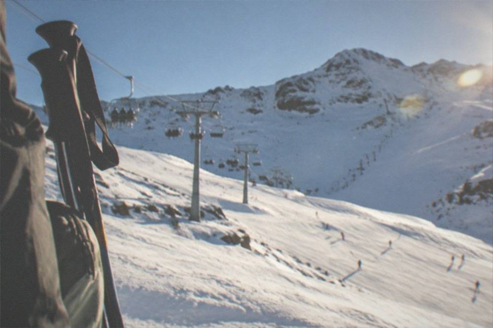 Deep snow on a mountain slope with clear skies and a distant ridgeline