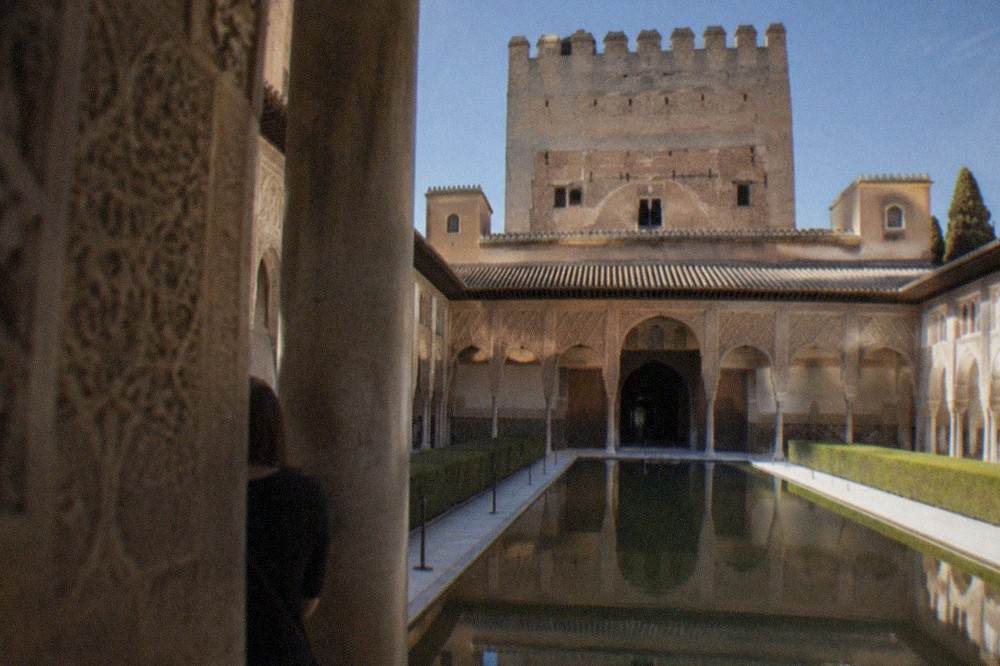 Carved stucco walls and Arabic inscriptions inside a Nasrid palace courtyard