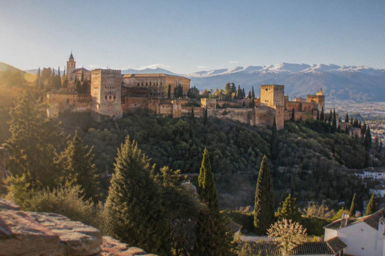 The walled Alhambra complex on its hill above the city of Granada, with the Sierra Nevada in the distance