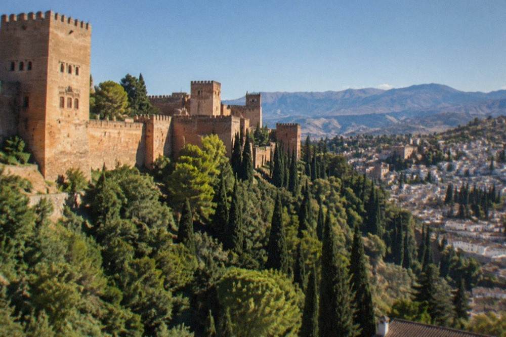 Aerial view of the Alhambra's walls and towers with the Albaicin quarter across the valley