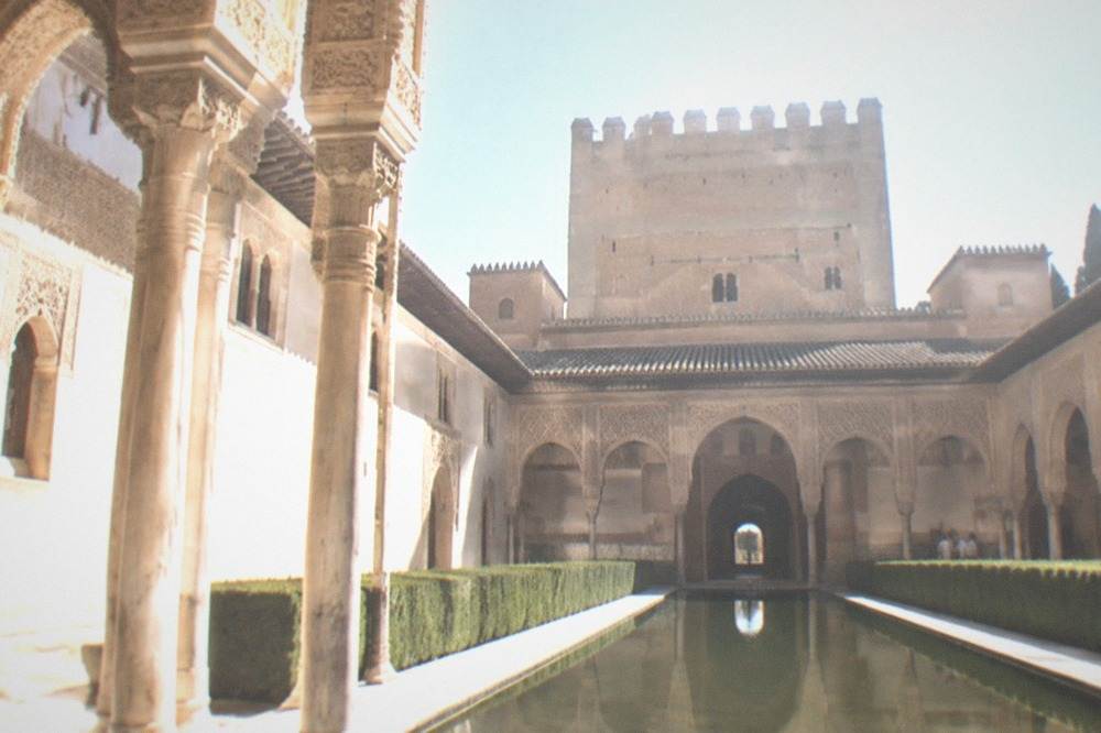 The ornate arched courtyard of the Nasrid Palaces with carved stucco walls