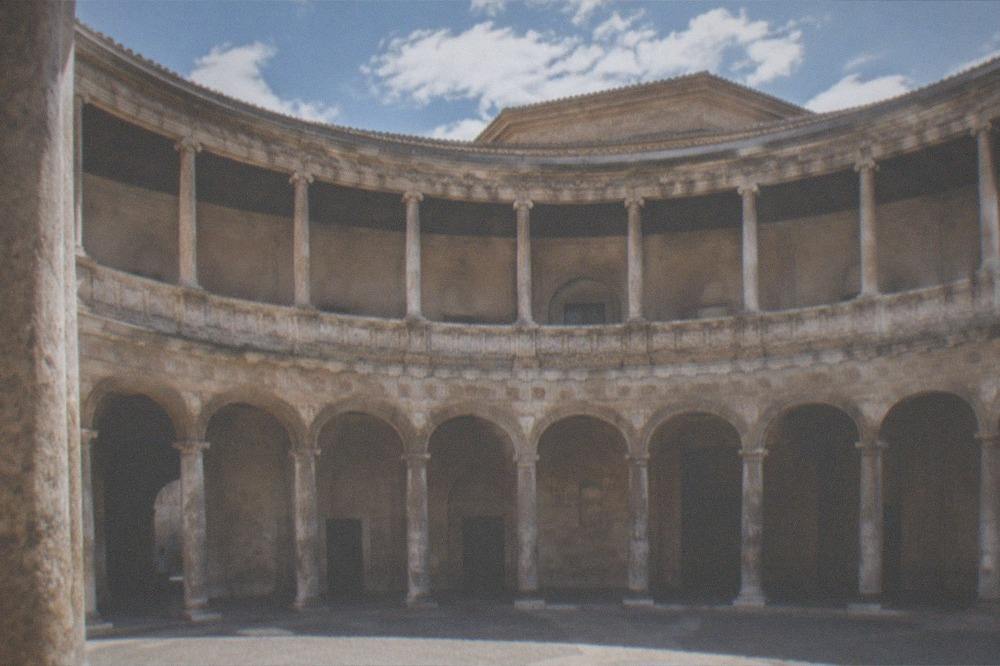 The circular stone courtyard inside the Palace of Charles V with its two tiers of arcades