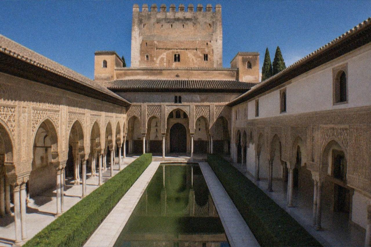 The illuminated Nasrid Palaces of the Alhambra seen against a dark evening sky in Granada