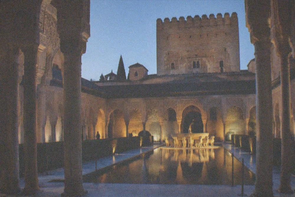 The Court of the Lions fountain glowing under night lighting inside the Nasrid Palaces