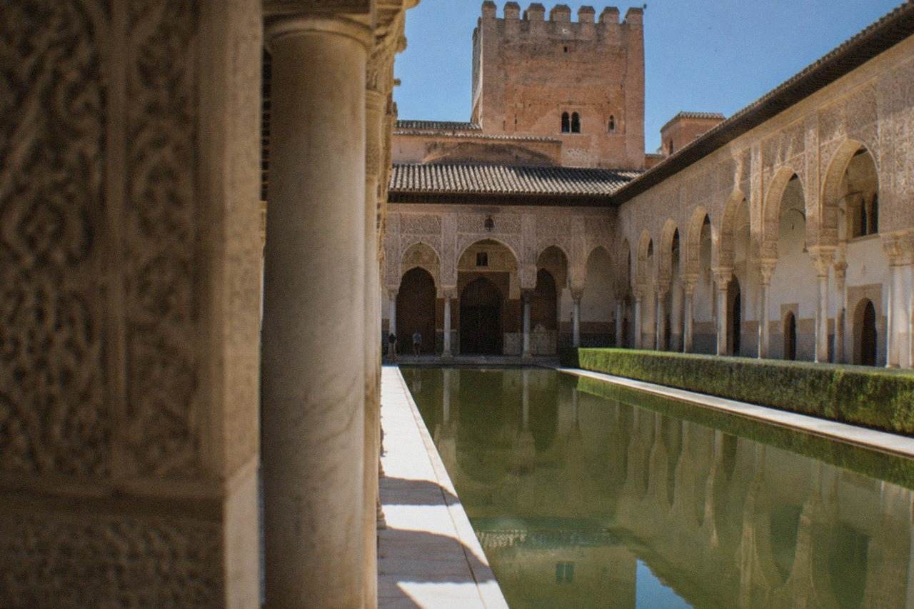 The ornate arches and carved stucco walls of the Nasrid Palaces inside the Alhambra