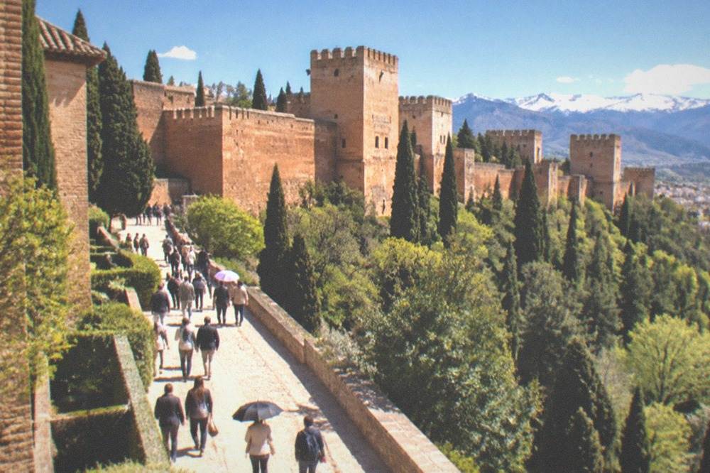 Spring crowds on the main path inside the Alhambra complex with the Sierra Nevada behind